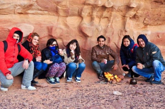 tourists in a camp with fire on