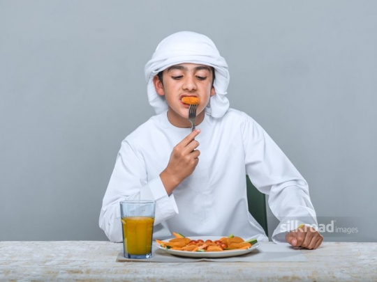 Middle Eastern kid eating|
