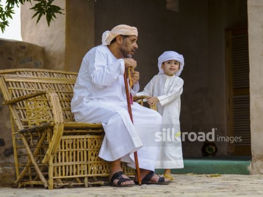 Boy with grandfather sitting outside|-