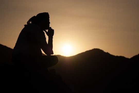 man sitting in wadi rum desert watching sunset scene