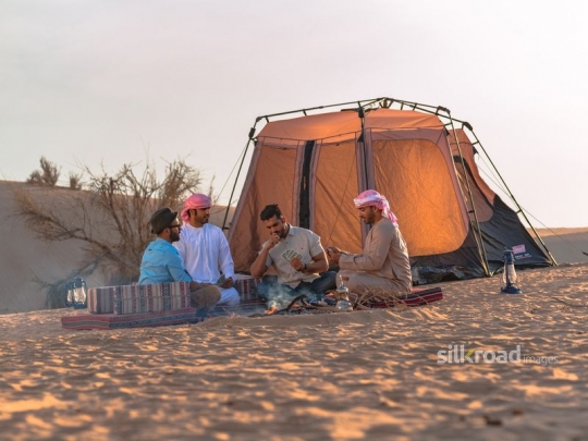 Friends gathering and playing cards in the desert