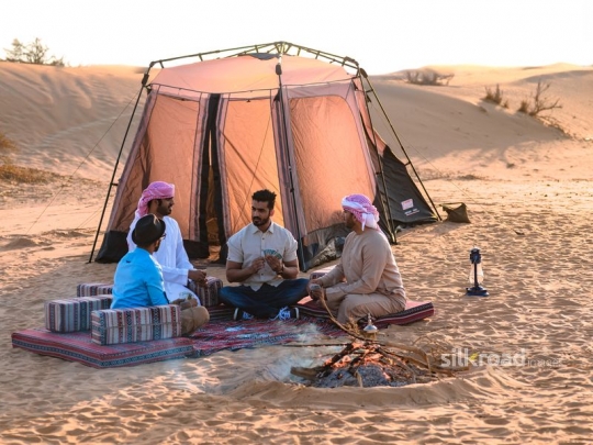 Friends playing cards in the desert camp