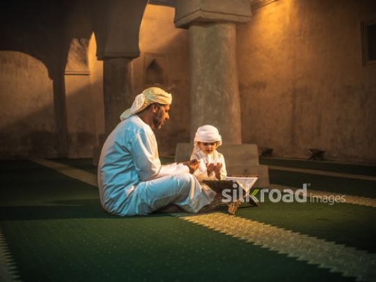 Boy and grandfather praying at the mosque|-