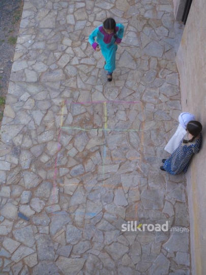 Girl jumping and playing with kids ouside|-