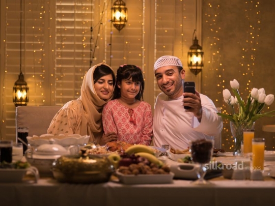 Middle Eastern father taking a selfie with his family