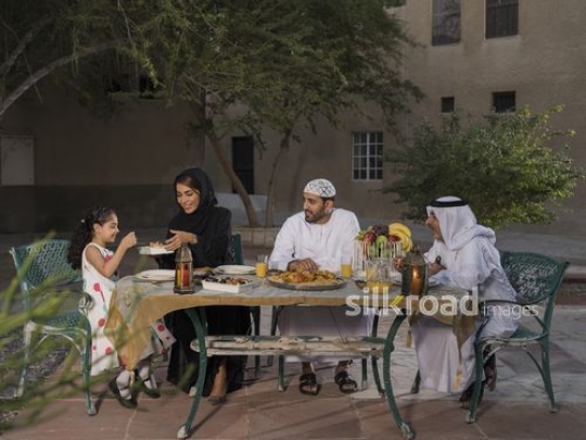 REPLACE - Arab mother offering kid food while sitting with two arab men during Iftar |-