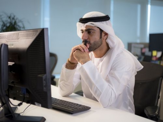 Successful business man sitting by his desk thinking|