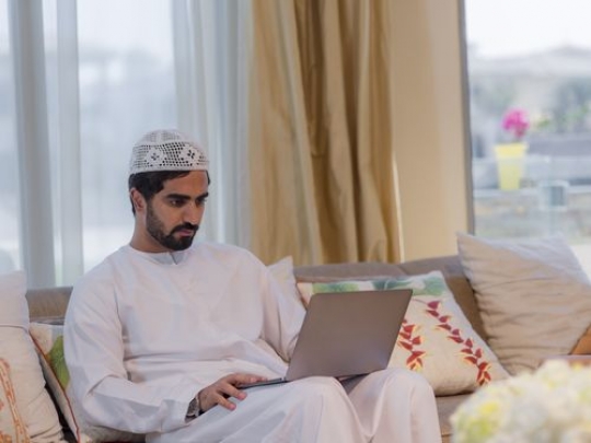 Arab man sitting on the couch with his laptop|-