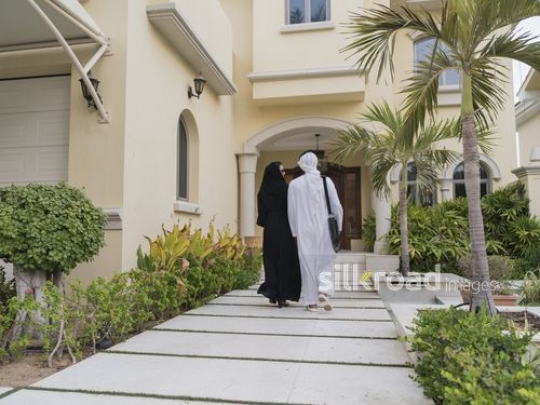 Arab couple walking to their house together|