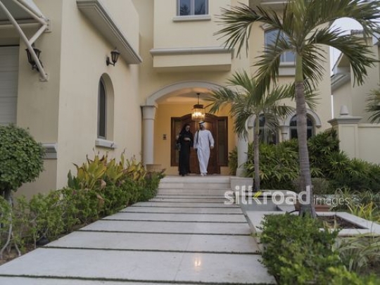 Middle Eastern man and woman leaving the house together|