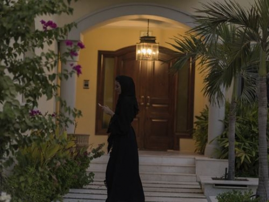 Arab woman standing outside the house|-