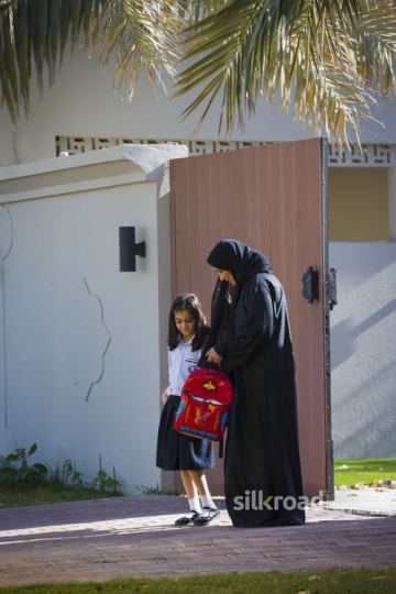 Middle Eastern mother and daughter standing outside the house|-