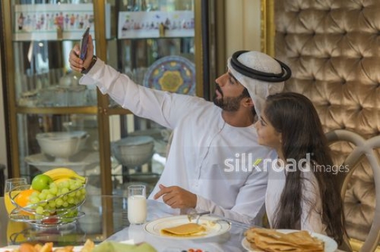 Arab father taking a selfie with his daughter|