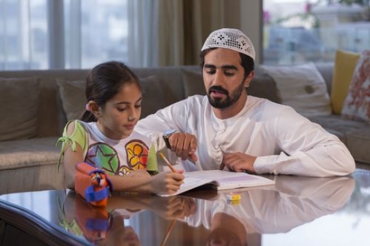 Arabian father helping his daughter on her homework |-