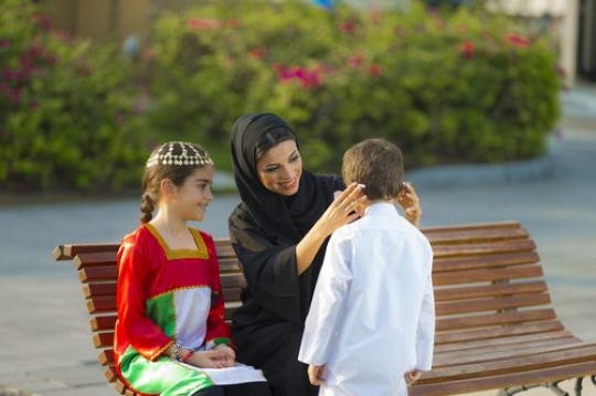 Portrait of a middle eastern mother and kids getting ready for national day|-
