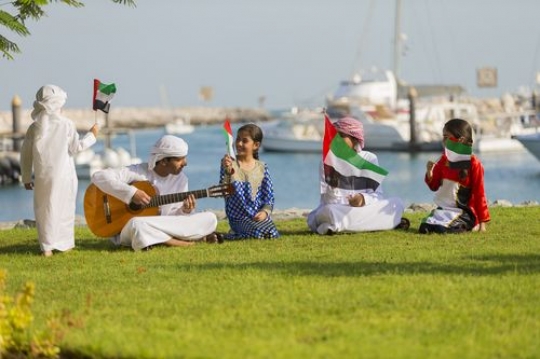 Arab kid standing and walking while the rest of the kids are singing along|-