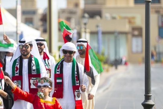 Family and friends representing their country at a UAE National Day parade|