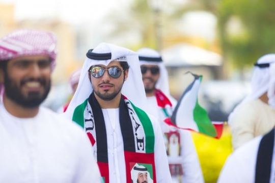 Arab men dressed in the UAE traditional attire at National Day parade|