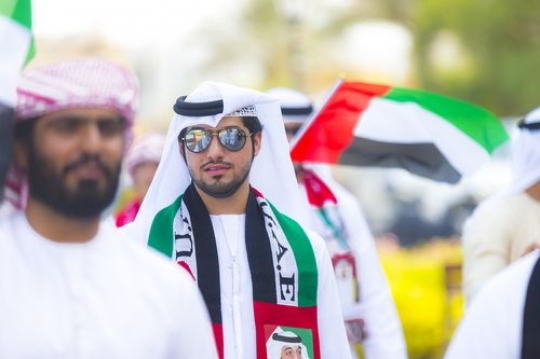 Arab man dressed in the UAE traditional attire at a National Day parade|
