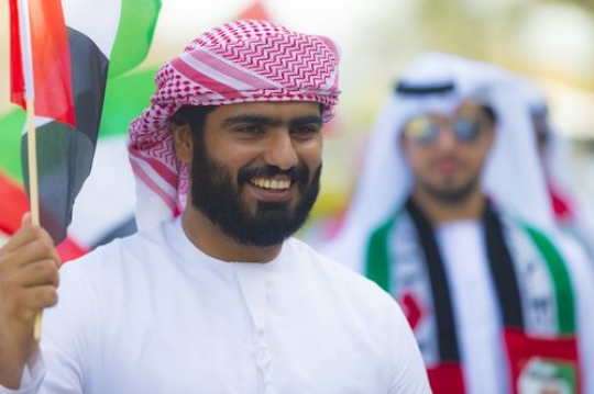 Arab man dressed in the traditional UAE attire celebrating National Day|
