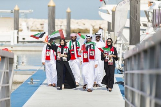 Arab Family and friends at a parade by the dock celebrating the UAE National Day|