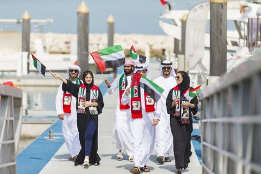 Arab family walking towards the dock during a National Day parade|