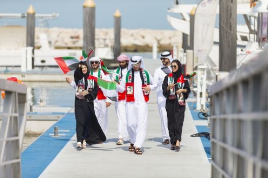 A group of family and friends on the dock celebrating UAE National Day|