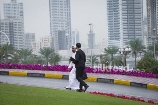 Two Middle Eastern business men walking together|-