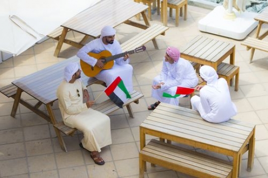 Top view of arab men sitting on the bench and celebrating National Day|