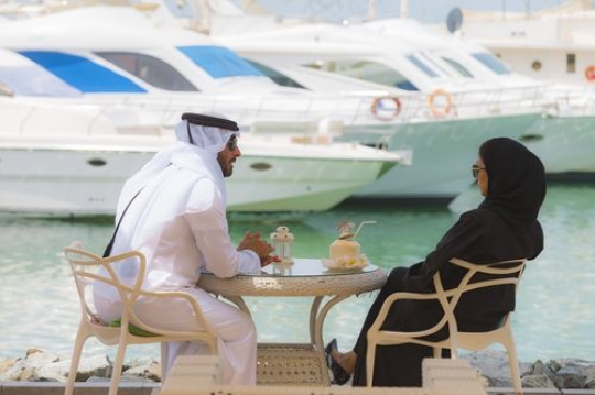 Arab couple sitting outside and talking to each other over |