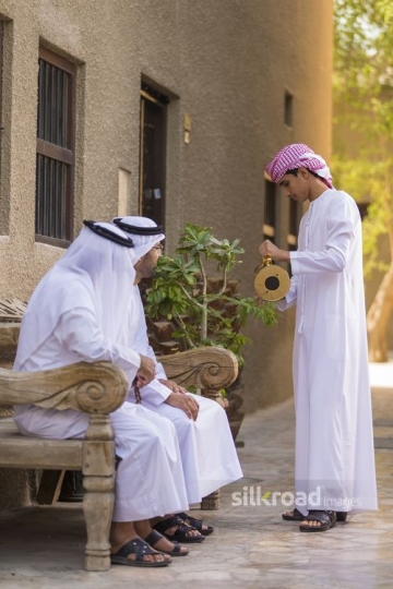 Arab son offering coffee to his father and grandfather |-