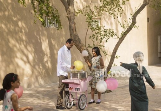 Arab man offering cotton candy to the kids|-