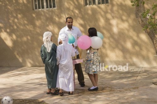Arabian man offering cotton candy to the kids|-