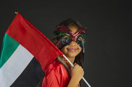 Girl carrying the UAE flag celebrating National Day