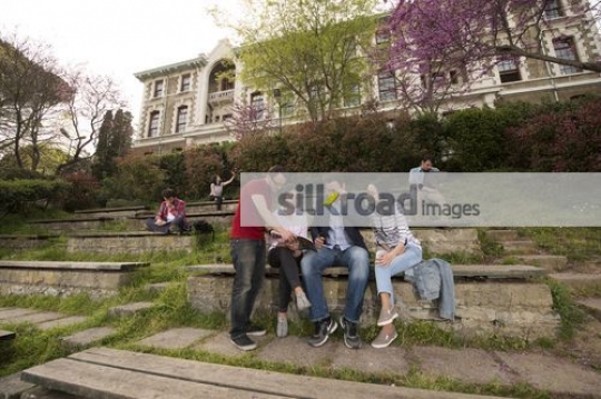 Students sitting together talking to the professor|