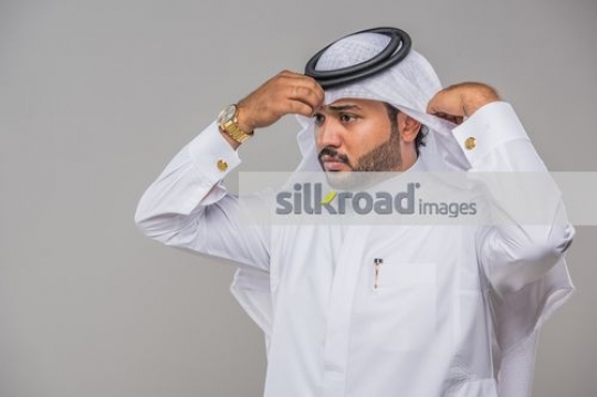 Middle Eastern Businessman fixing his thobe|