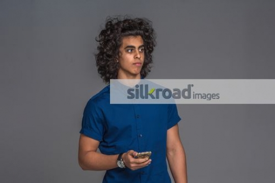 Middle Eastern man standing using his mobile|