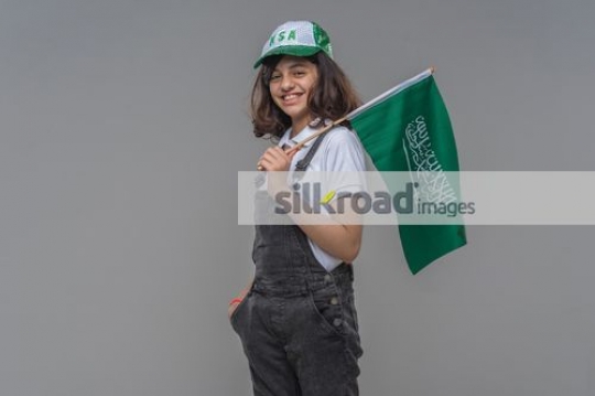 Young Arab girl carrying the KSA Flag|