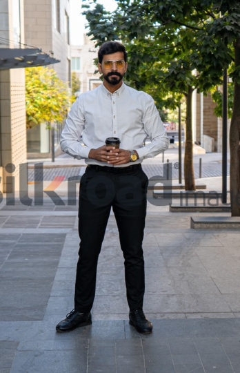 Man Walking Between Modern Buildings with Coffee Cup in Al Abdali Boulevard