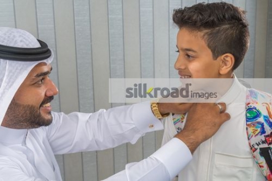 Businessman fixing the kids kandoura