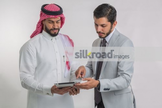 Middle Eastern Businessmen using the device|