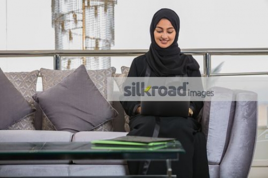 Arab Business woman sitting on the couch working |
