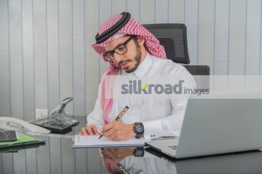Middle Eastern Businessman writing notes|