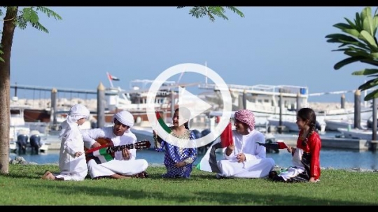 Middle Eastern family sitting on the grass celebrating the UAE National Day|