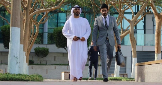 Middle Eastern Businessman walking with his colleague |-