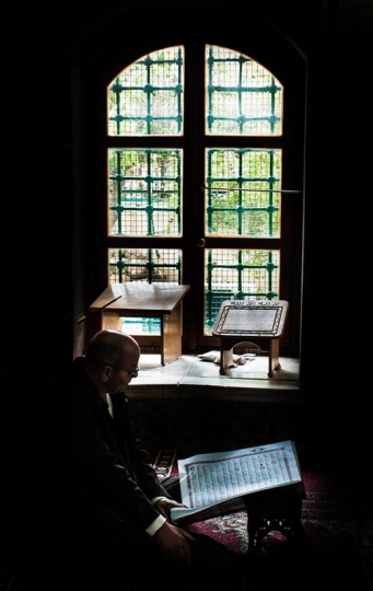 muslim man reading koran in jazzar pasha mosque