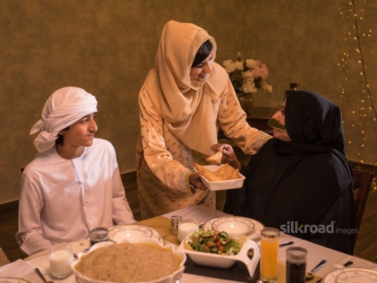 Mother serving puff pastry to grandmother|-