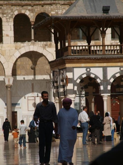 people walking in a yard inside a mosque