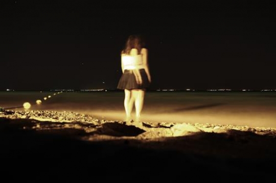 young woman standing on a sand near sea and looing to a horizon,aqaba