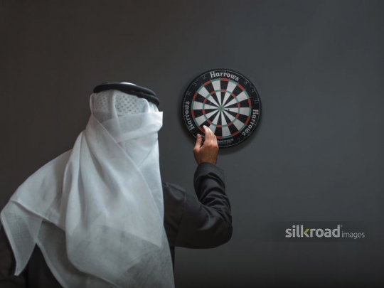 Man aiming at dart board